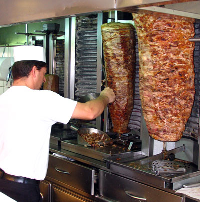gyros, garçom cortando carne de churrasco grego